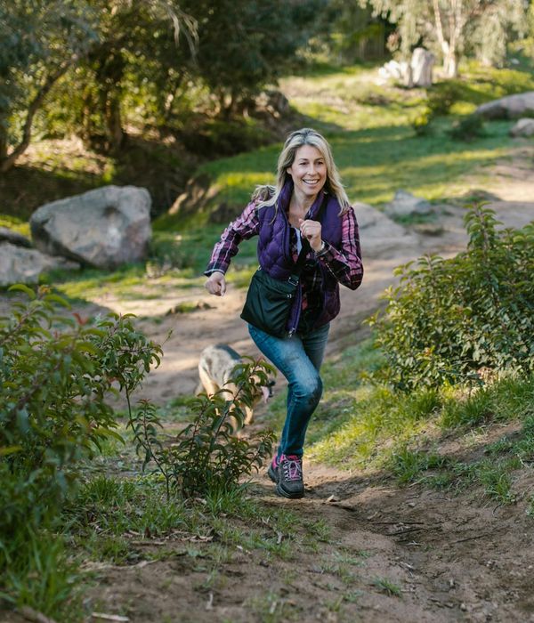 Woman feeling energized and happy outdoors in a sunny park.